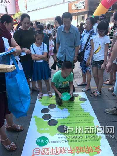 市民在宣傳點(diǎn)參加創(chuàng)文趣味游戲。 記者 朱虹 攝